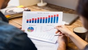 Closeup of businessman and woman discussing on stockmarket document in office